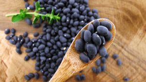Black beans in a wooden spoon grown in Idaho's Magic Valley by Mike Heath and Alvaro Peralta
