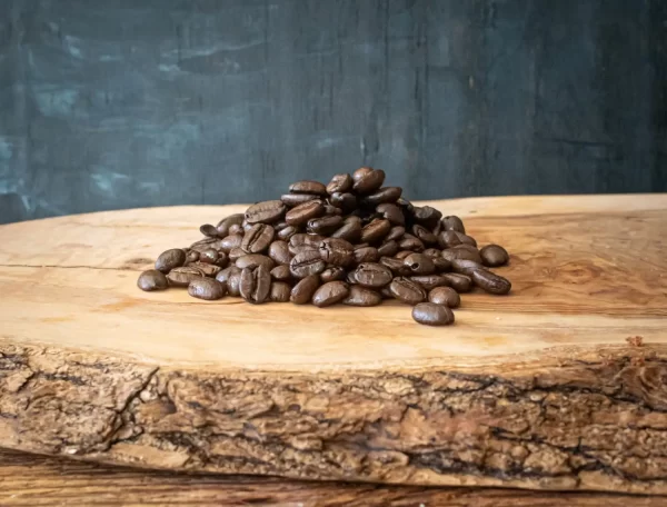A pile of roasted coffee beans on a board.