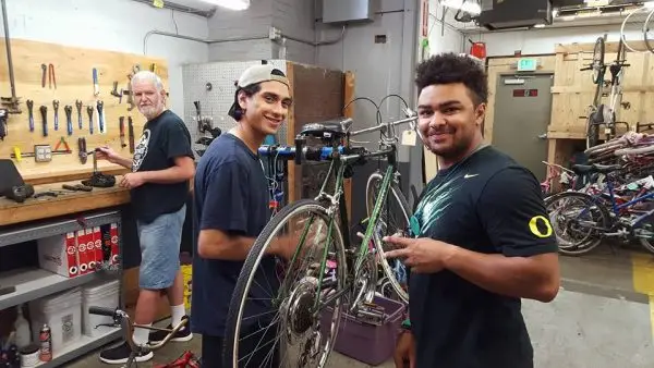 Team members repairing bicycles in The Northwest Hub nonprofit workshop in Salem, Oregon, supporting community transportation access
