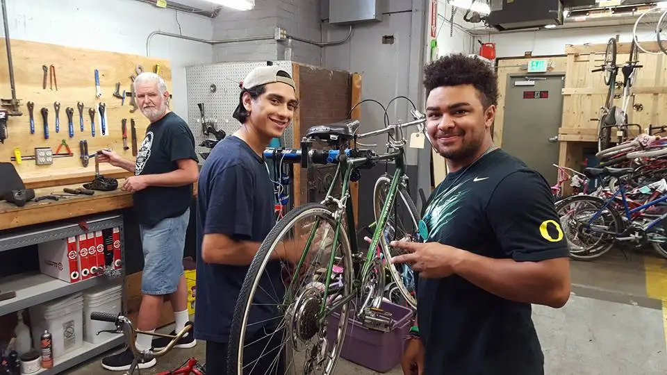Team members repairing bicycles in The Northwest Hub nonprofit workshop in Salem, Oregon, supporting community transportation access