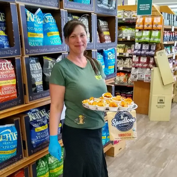 LifeSource team member offering samples of potato chips inside the store during Food Fair.