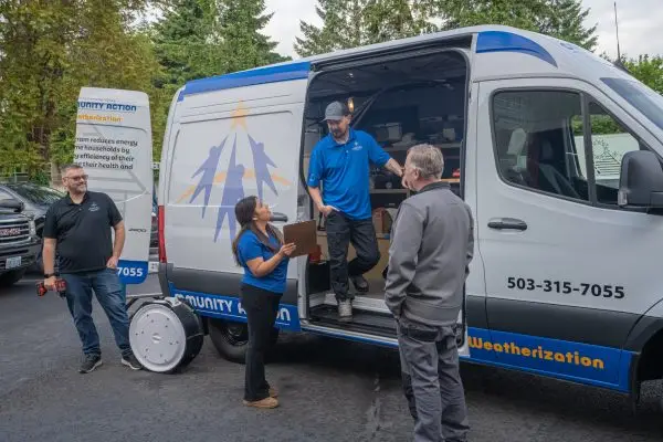 Mid-Willamette Valley Community Action weatherization team members gathered beside a weatherization service van.